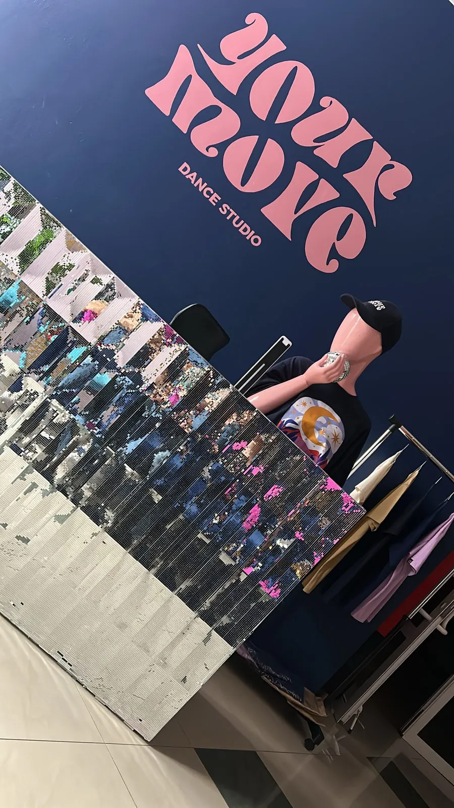 Stojak z merchem Your Move — bluzy i topy z logo studia